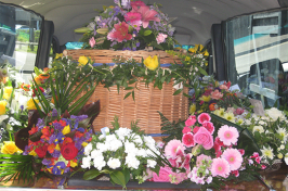 Wicker coffin with funeral flowers